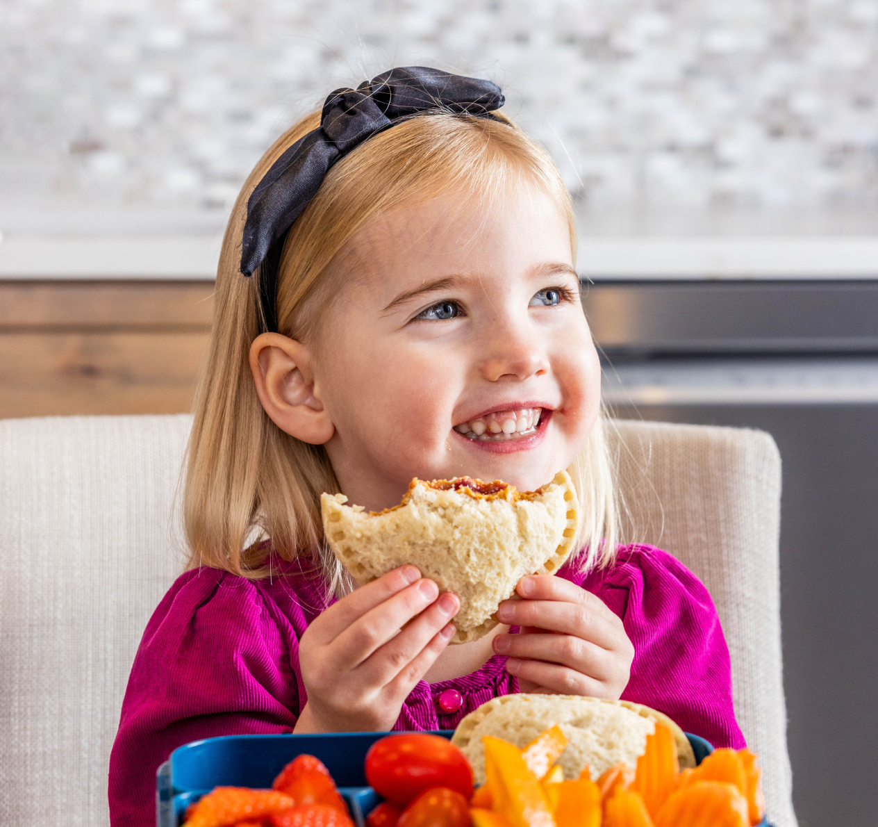 little girl with blonde hair holding Peanut Butter and Grape Spread Sando
