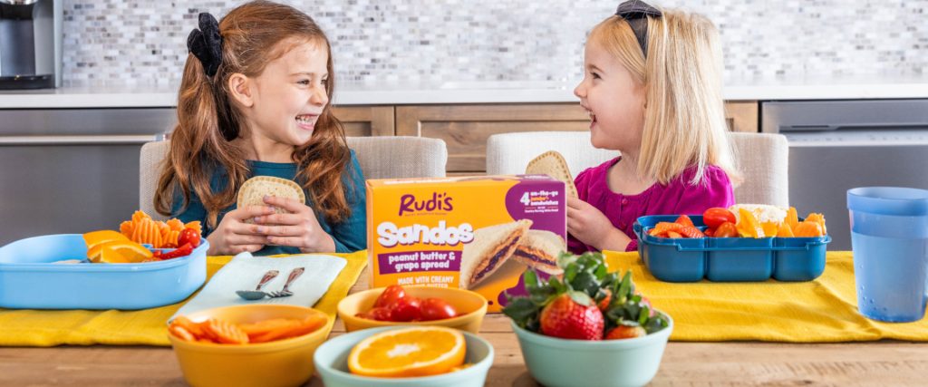 Two children eating Rudi's Sandos at the dinner table 